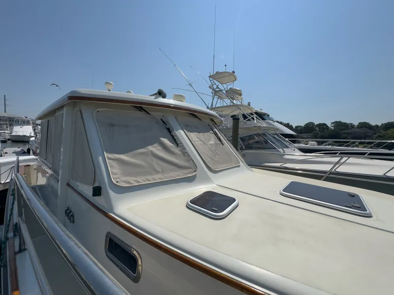 Slide: The Image of A 2002 Sabre 36 Express docked in a marina. It features a closed canopy and sleek lines. - 47