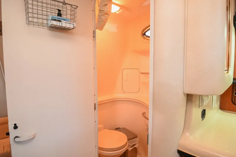 Slide: The Image of 2001 Sea Ray 340 Sundancer bathroom interior with toilet and storage basket. - 42