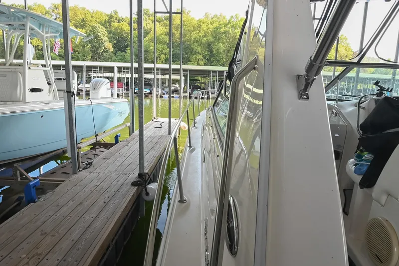 Slide: The Image of 2001 Sea Ray 340 Sundancer docked beside a blue boat in a marina. - 49