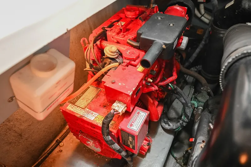 Slide: The Image of Engine compartment of a 2001 Sea Ray 340 Sundancer boat, featuring a red engine. - 48