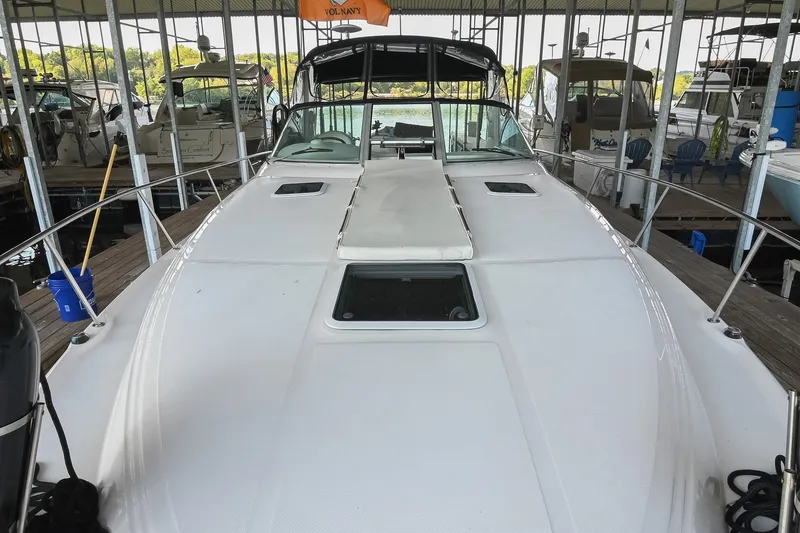 Slide: The Image of 2001 Sea Ray 340 Sundancer docked in a marina, showcasing its sleek deck design. - 51