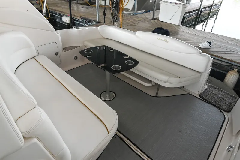 Slide: The Image of 2001 Sea Ray 340 Sundancer boat interior with white seating and a black table. - 9