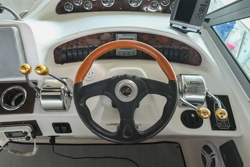 Slide: The Image of Steering wheel and controls of a 2001 Sea Ray 340 Sundancer boat cockpit. - 19
