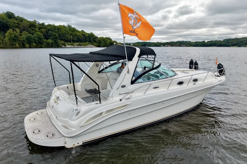 Slide: The Image of 2001 Sea Ray 340 Sundancer boat on a lake with orange flag, overcast sky. - 69