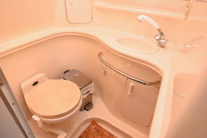 Slide: The Image of Compact bathroom in a 2001 Sea Ray 340 Sundancer yacht, featuring a toilet and sink. - 43