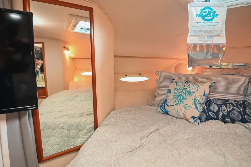 Slide: The Image of Cozy cabin interior of 2001 Sea Ray 340 Sundancer with nautical-themed pillows and mirror. - 36