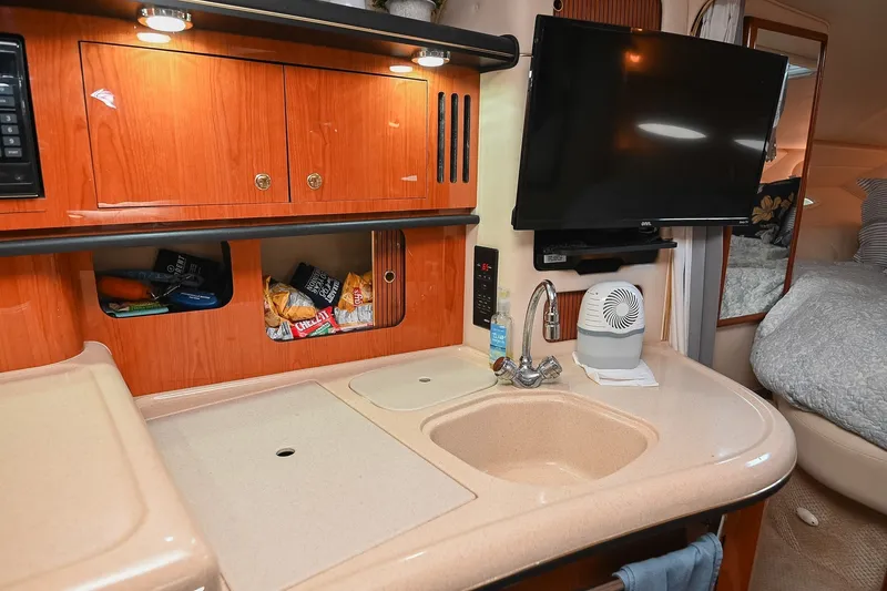 Slide: The Image of 2001 Sea Ray 340 Sundancer interior with kitchenette, TV, and cozy sleeping area. - 30