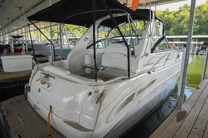 Slide: The Image of 2001 Sea Ray 340 Sundancer docked in a marina, featuring sleek white design. - 2