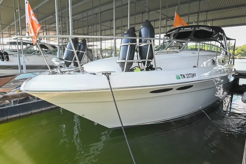 The Image of 2001 Sea Ray 340 Sundancer docked in a marina, featuring sleek design and orange flags. - 0