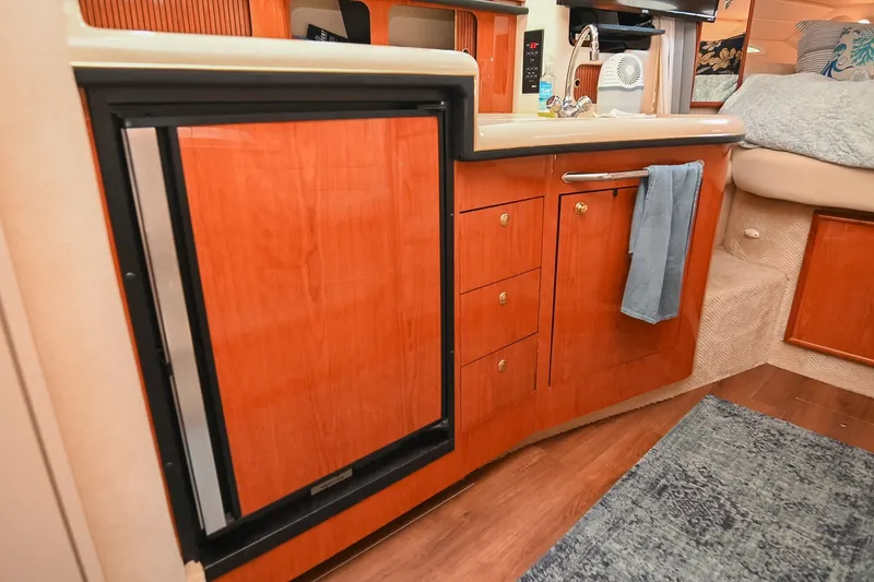 Slide: The Image of Interior of 2001 Sea Ray 340 Sundancer yacht with wooden cabinetry and compact kitchen area. - 29