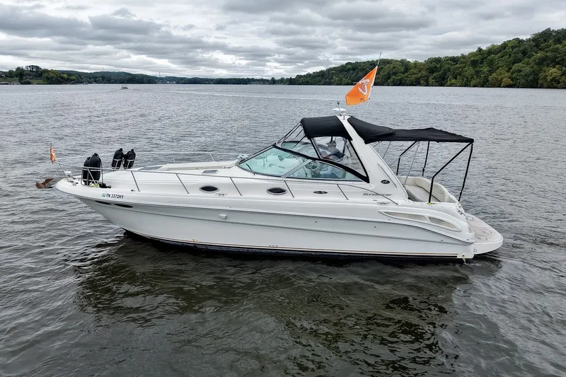Slide: The Image of 2001 Sea Ray 340 Sundancer boat cruising on a lake under cloudy skies. - 68