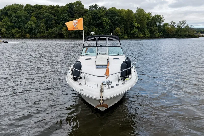Slide: The Image of 2001 Sea Ray 340 Sundancer boat on a calm lake with lush green trees. - 67