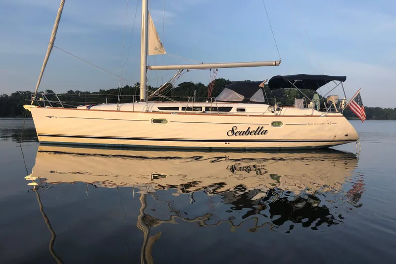 The Image of 2006 Jeanneau Sun Odyssey 45 sailboat named "Seabella" on calm water with American flag. - 0