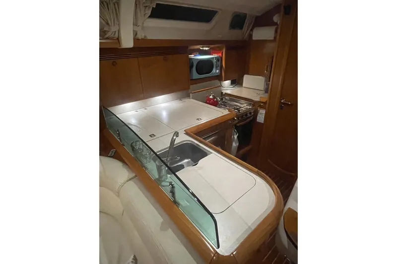 Slide: The Image of Interior of 2006 Jeanneau Sun Odyssey 45 yacht, featuring a compact, well-equipped kitchen area. - 20