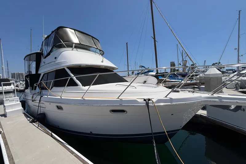 The Image of 1996 Bayliner 3587 Motoryacht docked at marina under clear blue sky. - 1