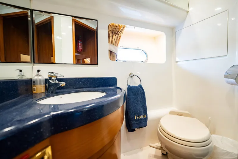 Slide: The Image of Das Bild zeigt ein Badezimmer auf einer Yacht mit einem blauen Waschbecken, einem Spiegel und einem Fenster. - 31