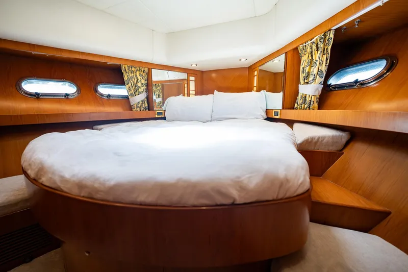 Slide: The Image of Die Kabine der Horizon 62 Motor Yacht von 2003 zeigt ein großes, rundes Bett mit Holzwänden und Bullaugen. - 36