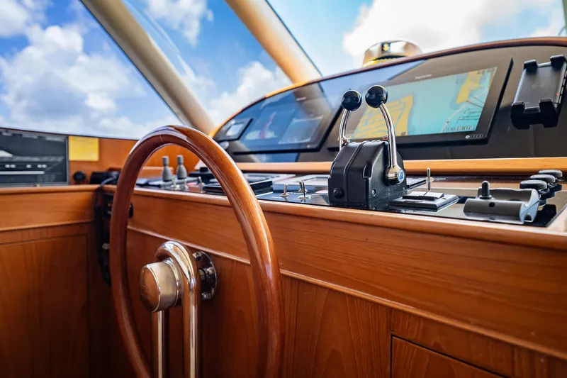Slide: The Image of Das Bild zeigt das Steuerhaus einer Horizon 62 Motor Yacht von 2003 mit einem Holzlenkrad und modernen Instrumenten. - 21