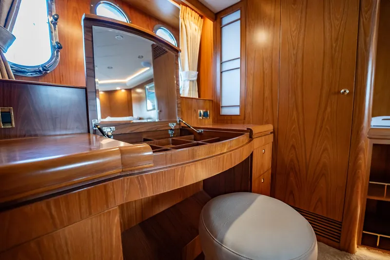 Slide: The Image of Ein eleganter Schminktisch aus Holz mit Spiegel und Hocker in einer Yachtkabine. - 28