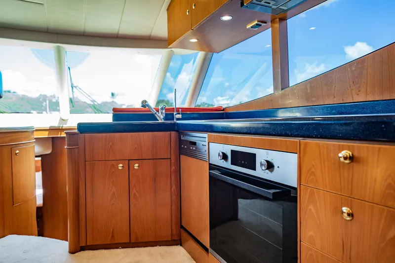 Slide: The Image of Die Küche einer Horizon 62 Motoryacht von 2003 mit Holzschränken und modernen Geräten. - 24