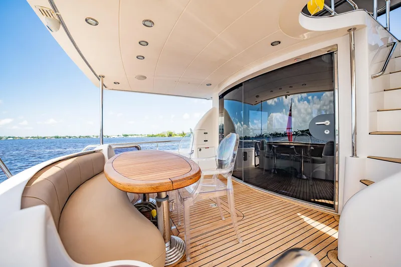 Slide: The Image of Die Horizon 62 Motor Yacht von 2003 zeigt ein elegantes Achterdeck mit einem runden Holztisch und bequemen Sitzgelegenheiten. - 45