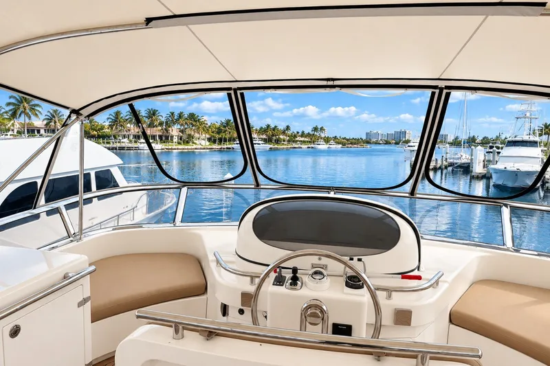 Slide: The Image of Cockpit view of 2003 Horizon 62 Motor Yacht overlooking marina with palm trees and blue sky. - 70