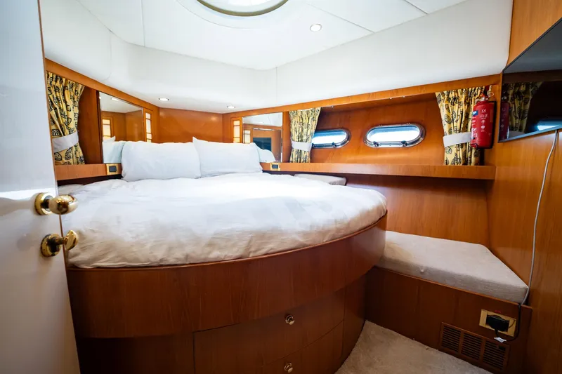Slide: The Image of Die Kabine der Horizon 62 Motor Yacht von 2003 zeigt ein rundes Bett, Holzwände und Bullaugen. - 35