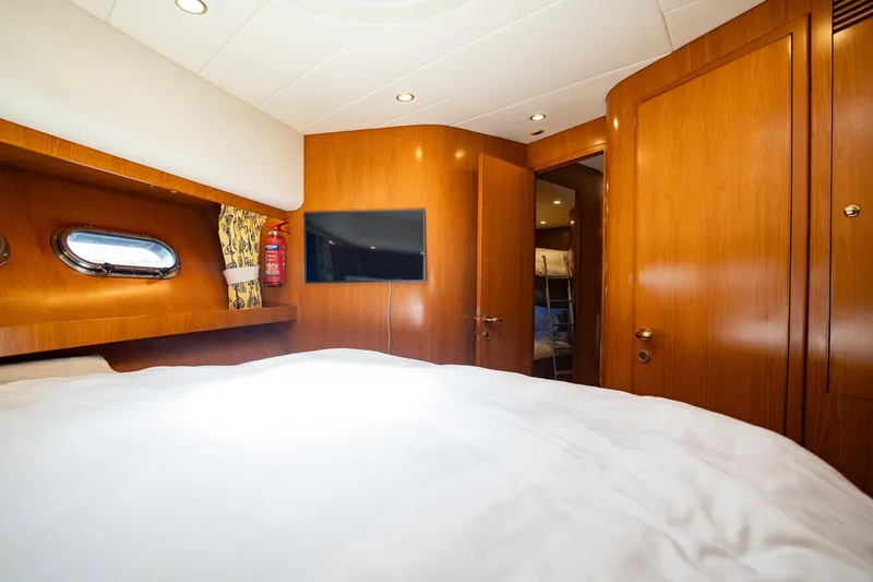 Slide: The Image of Die Kabine einer Horizon 62 Motoryacht von 2003 mit Holzverkleidung und einem Bullauge. - 38