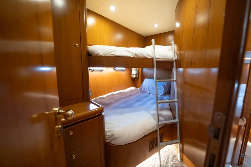 Slide: The Image of Ein gemütliches Schlafzimmer mit Etagenbetten in einer Yacht, warm beleuchtet mit Holzverkleidung. - 42