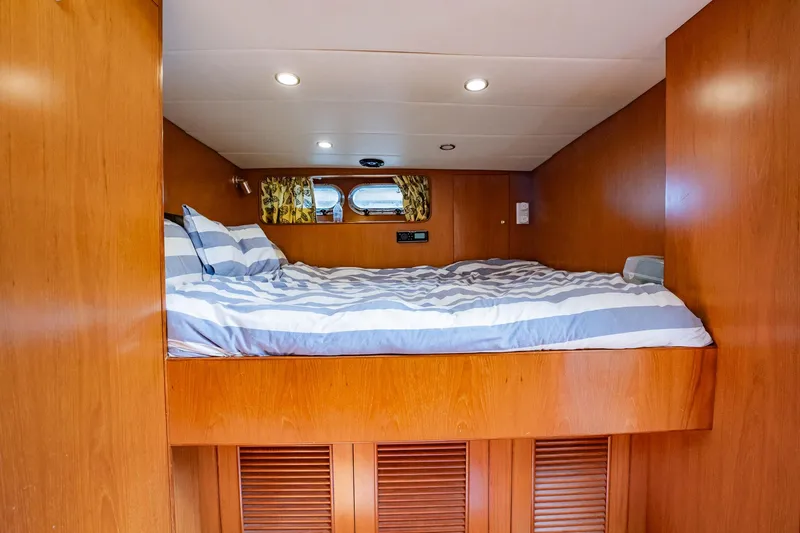 Slide: The Image of Ein gemütliches Schlafzimmer mit einem Doppelbett, Holzwänden und einem kleinen Fenster an der Seite. - 48