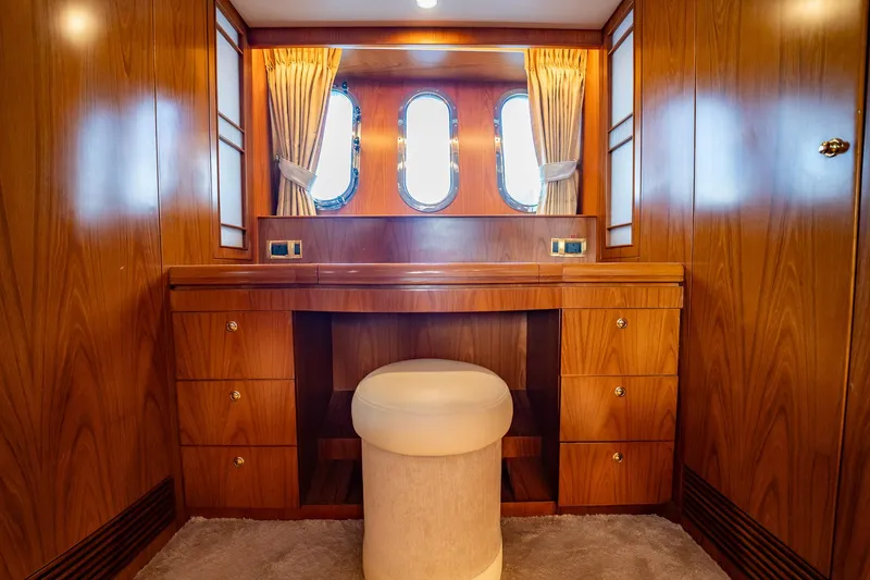 Slide: The Image of Ein eleganter Schminktisch aus Holz mit Hocker in einer Yachtkabine, umgeben von Vorhängen und Bullaugen. - 27