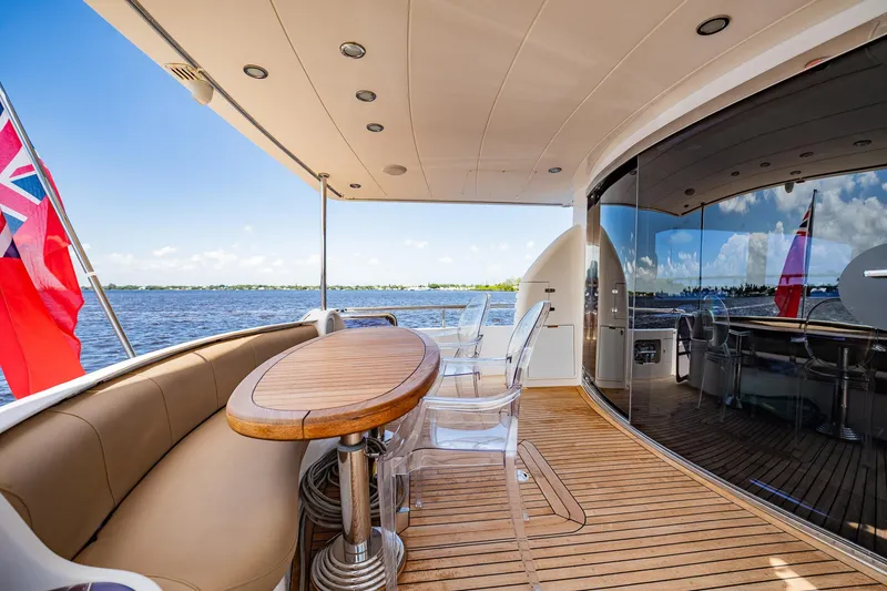 Slide: The Image of Die Horizon 62 Motor Yacht von 2003 zeigt ein elegantes Achterdeck mit Holztisch und bequemen Sitzgelegenheiten. - 46