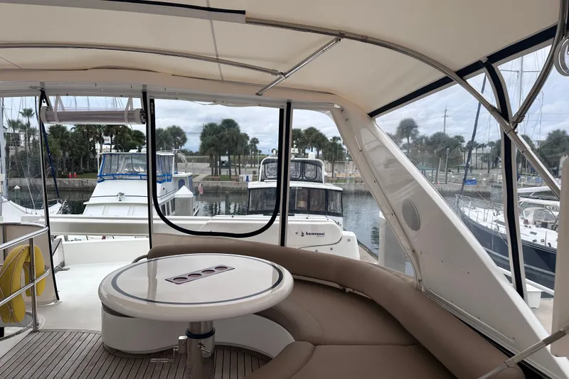 Slide: The Image of Interior view of 2003 Horizon E62 Motor Yacht with seating and marina backdrop. - 73