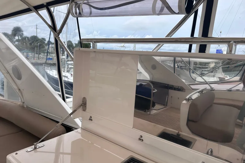 Slide: The Image of Interior view of a 2003 Horizon E62 Motor Yacht, showcasing seating and marina backdrop. - 69