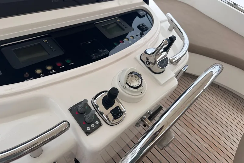 Slide: The Image of Control panel of a 2003 Horizon E62 Motor Yacht with navigation instruments and throttle controls. - 74