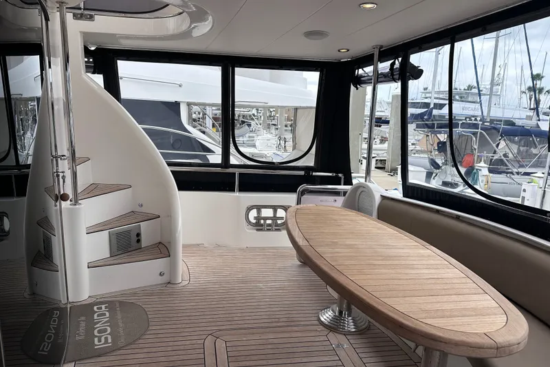 Slide: The Image of Luxurious interior of 2003 Horizon E62 Motor Yacht with spiral staircase and wooden table. - 82