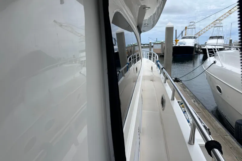 Slide: The Image of 2003 Horizon E62 Motor Yacht docked at marina, side view with reflection. - 88