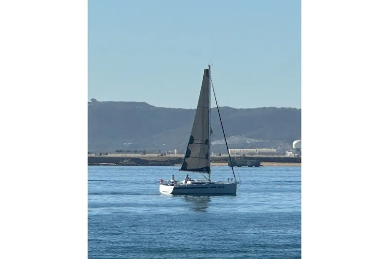 Slide: The Image of 2023 Jeanneau Sun Odyssey 349 sailing on calm waters with distant hills. - 17