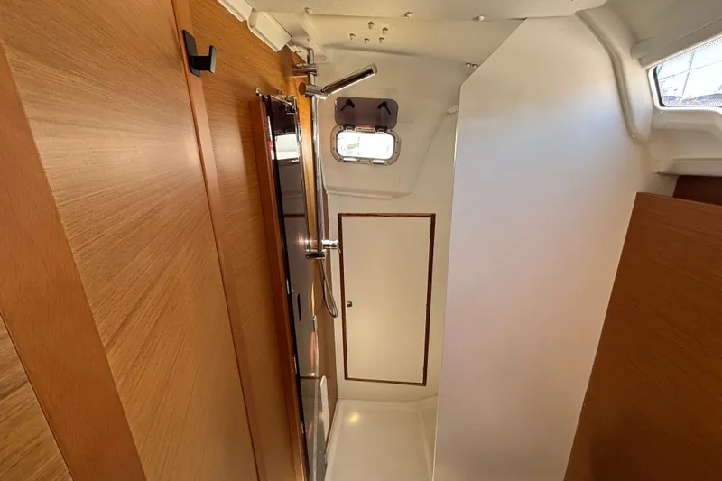 Slide: The Image of Interior of 2023 Jeanneau Sun Odyssey 349 sailboat, featuring wooden paneling and a compact design. - 14