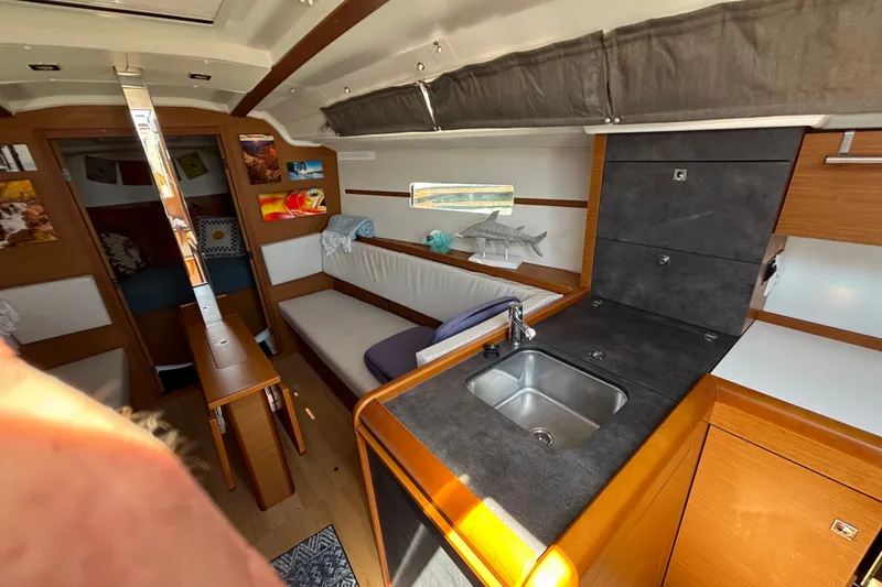 Slide: The Image of Interior of 2023 Jeanneau Sun Odyssey 349 yacht, featuring modern kitchen and cozy seating area. - 16
