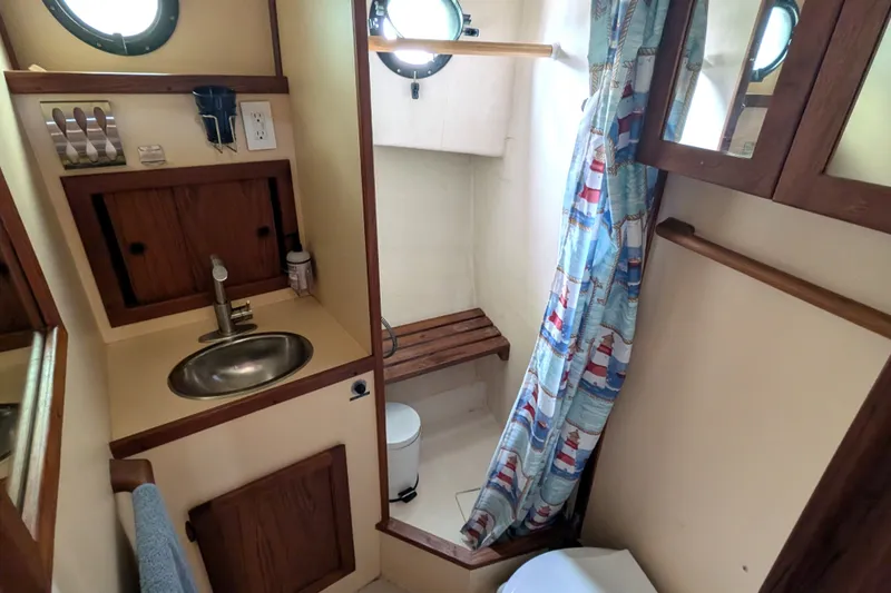 Slide: The Image of Bathroom interior of a 1993 Nordic Tug 32, featuring sink, shower, and nautical decor. - 42