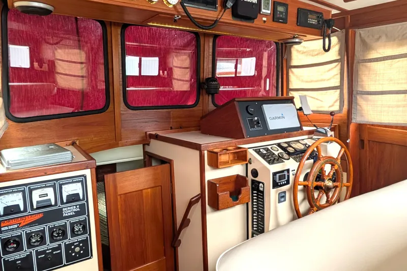 Slide: The Image of Cozy 1993 Nordic Tug 32 helm with wooden accents and modern navigation equipment. - 23