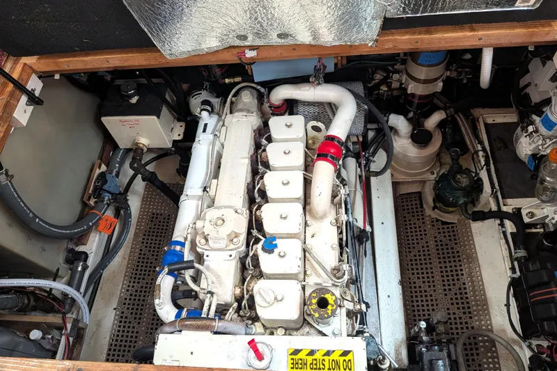 Slide: The Image of Engine compartment of a 1993 Nordic Tug 32, showcasing mechanical components and piping. - 44