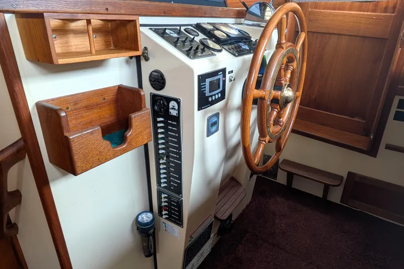 Slide: The Image of 1993 Nordic Tug 32 helm with wooden steering wheel and control panel. - 33