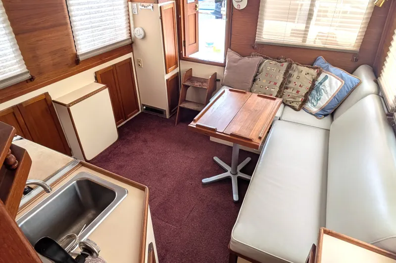 Slide: The Image of Interior of a 1993 Nordic Tug 32, featuring a cozy seating area and compact kitchen. - 19