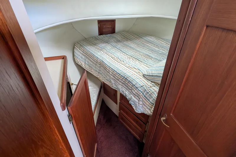 Slide: The Image of Cozy cabin interior of 1993 Nordic Tug 32 with striped bedding and wooden cabinetry. - 38