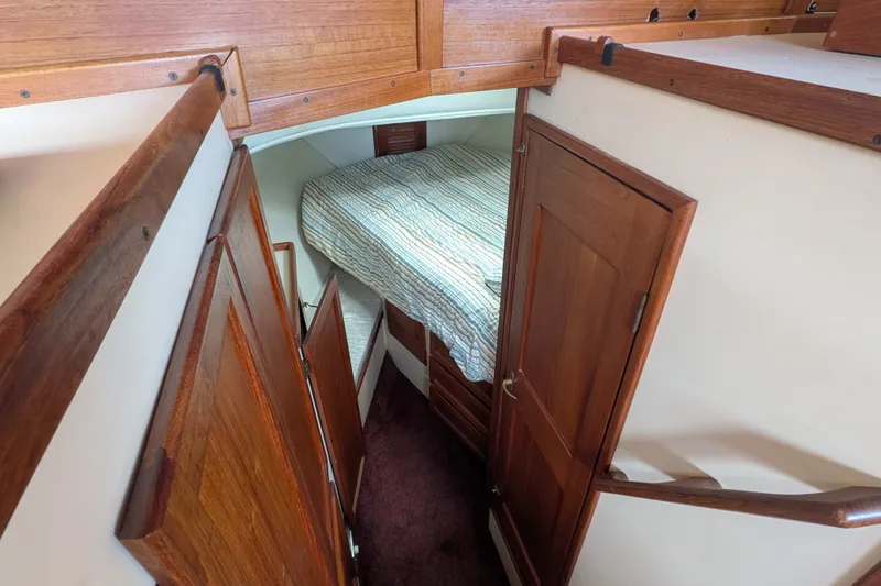 Slide: The Image of Cozy cabin interior of 1993 Nordic Tug 32 with wooden finishes and striped bedding. - 37
