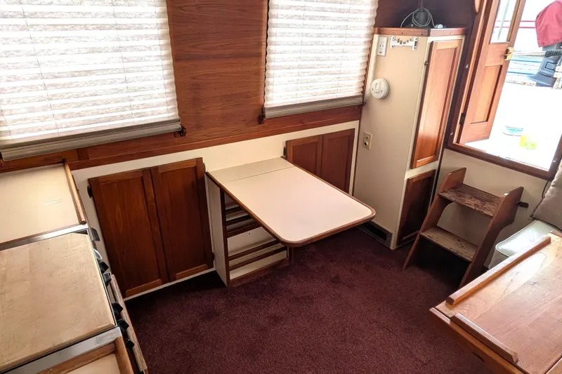 Slide: The Image of Interior of a 1993 Nordic Tug 32, featuring wood paneling and a compact dining area. - 15