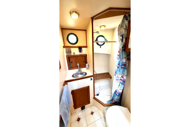 Slide: The Image of Bathroom interior of a 1993 Nordic Tug 32, featuring a sink, mirror, and nautical decor. - 41