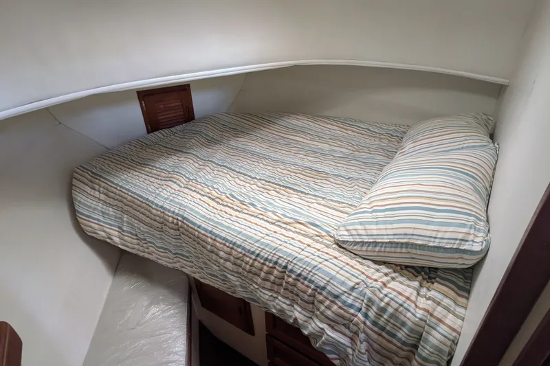 Slide: The Image of Cozy cabin bed in 1993 Nordic Tug 32 with striped bedding. - 39